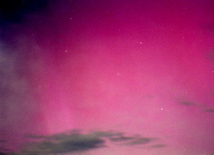 Slika prikazuje severni sij 16. julija 2000, škrlaten z žarki. Pogled iz Slovenske Bistrice. Foto: Javor Kac.